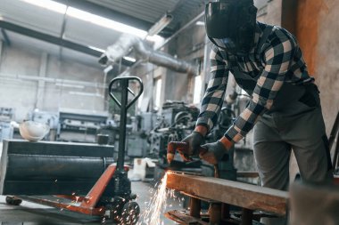 Demir kaynaklama. Üniformalı fabrika çalışanı içeride..