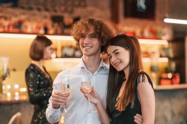 Genç kadın ve erkek kadeh kaldırarak kutlama yapıyorlar..