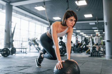 Fitness topunu kullanarak egzersiz yapmak. İnce vücutlu spor elbiseli kadın spor salonunda..