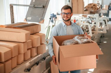 Kutuyu tutuyorum. Beyaz elbiseli matbaacı içeride..