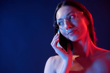 Telefonda sohbet ediyorduk. İçerideki neon ışıkta duran genç bir kadının portresi..