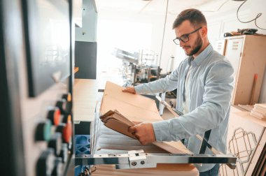 Ahşap çarşaflarla çalışmak. Beyaz elbiseli, matbaadaki adam içeride..