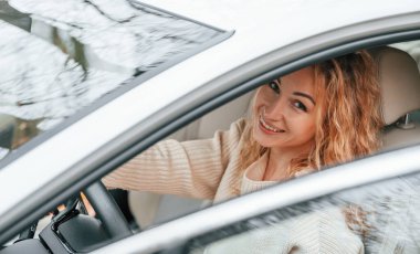 Kapı açıkken. Genç bayan arabada oturuyor..