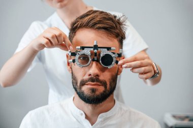Optometrik cihaz. Klinikteki kadın doktor adamın görüşünü kontrol etti..
