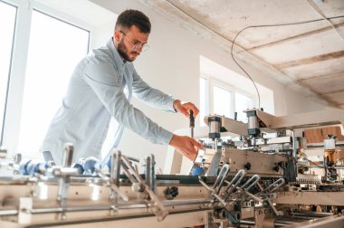 Bir baskı makinesi kuruyorum. Beyaz elbiseli tipografi işçisi içeride..