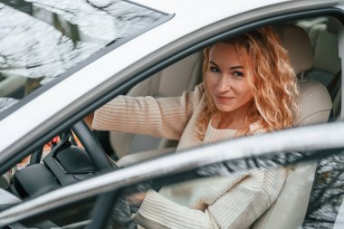 Kapı açıkken. Genç bayan arabada oturuyor..