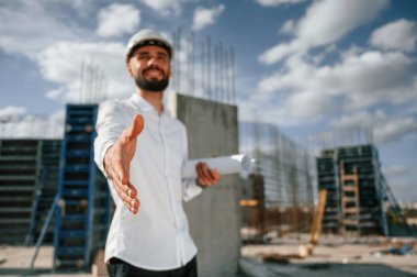 Bir anlaşma yapıyorum. Elimi uzatıyorum. Üniformalı adam inşaat alanında çalışıyor..