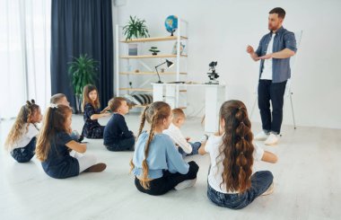Jest dilini öğreniyorum. Okulda öğretmenle birlikte bir grup çocuk öğrenci..