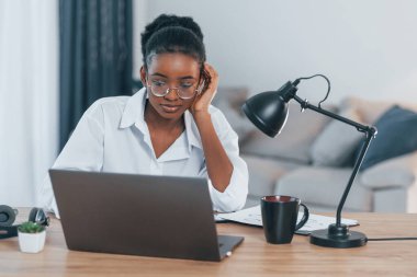 Çevrimiçi bağlantı. Beyaz gömlekli Afro-Amerikan kadın evde..