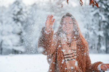 Karı atıyorum. Güzel genç bir kadın kış ormanında dışarıda..
