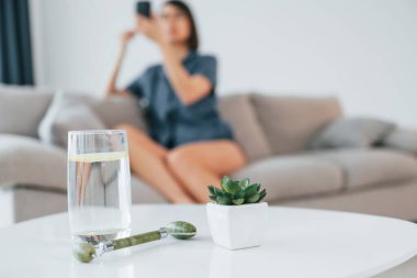 Makyaj yapıyordum. Masanın manzarasını bir bardak suyla kapat. Genç bayan evde. Güzellik kavramı.