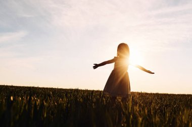 Güneş ışığının sıcaklığının tadını çıkarıyorum. Mutlu kız yazın dışarıda gezintiye çıkar..