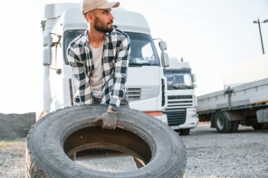 Kırık lastikle. Genç kamyon şoförü gündüz vakti aracıyla geliyor..