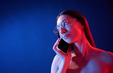 Telefonla konuşuyorum. İçerideki neon ışıkta duran genç bir kadının portresi..