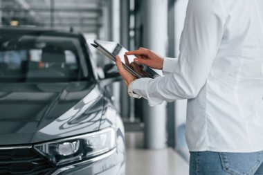 Tablet kullanıyorum. Kadın gündüz vakti otosalonda..