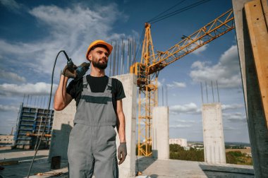 Durma ve tutma talimi. Üniformalı adam inşaat alanında çalışıyor..