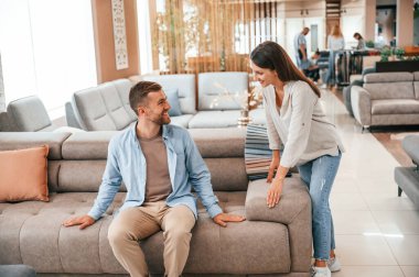 Oturup dinleniyorum. Dükkandaki yatağı ve kanepeyi seçen çift..