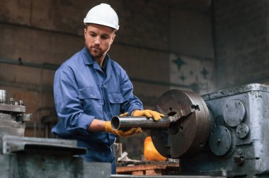 Otomatik makineyi çalıştırıyorum. Mavi üniformalı fabrika işçisi içeride..