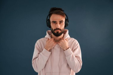 Kulaklıkla. Yakışıklı adam stüdyoda mavi arka planda..