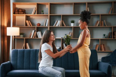 Çiçek veren melez bir kız. Genç anne kızıyla birlikte dairede..