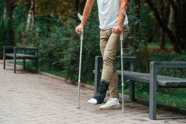 Manzarayı kapat. Koltuk değnekli adam dışarıdaki parkta. Bacağımdan yaralandı..