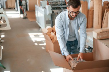 Tahta çarşafları paketliyorum. Beyaz elbiseli matbaacı içeride..