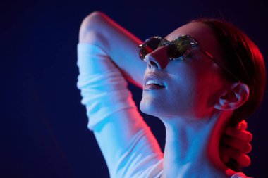 Gözlük takıyordu. İçerideki neon ışıkta duran genç bir kadının portresi..