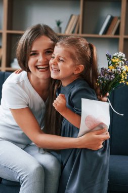Anneler Günü kavramı. Hediye vermek. Kızıyla birlikte genç bir kadın dairede..