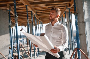 Ayakta ve okuma planı. Gündüz vakti inşaatta çalışan bir adam var..