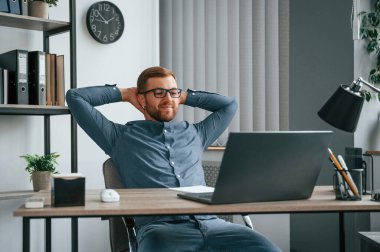 Mola verdim. Adam modern büroda çalışıyor. İş ve serbest meslek anlayışı.