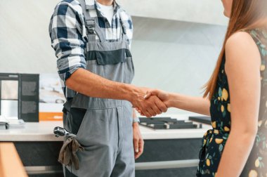 Üniformalı tesisatçı kadına mutfakta yardım etti. Tokalaşıyorum..