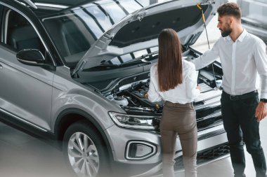 Kaputun altında ne var? Beyaz elbiseli bir adam araba galerisinde birlikte..