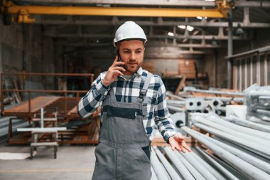 Telefonla konuşuyorum. Üniformalı fabrika çalışanı içeride..