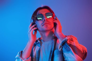 Conception of futuristics. Man standing in the studio with neon light.