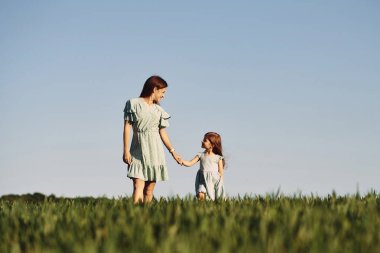El ele tutuşarak. Anne ve kızı yazın açık havada eğleniyorlar..