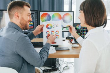 Doğru renkleri seçiyorum. Ofiste birlikte çalışan iki tasarımcı..