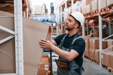 Kutuyu işaretliyorum. Üniformalı eleman gündüz vakti depoda çalışıyor..
