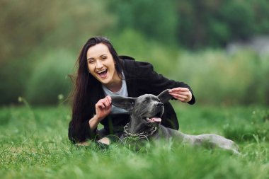 Neşeli bir ruh hali. Kulaklarından tutarak. Genç esmer kız köpeğiyle dışarıda yürüyüş yapıyor..