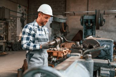 Metal işleme. Üniformalı fabrika çalışanı içeride..