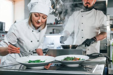 Birlikte çalışmak. Profesyonel aşçı mutfakta yemek hazırlıyor..