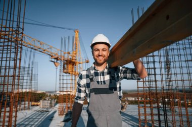 Crane arkada. Tahta bir parça tutuyorum. Gündüz vakti inşaatta çalışan bir adam var..