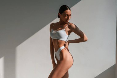 Stüdyoda, güneş ışığı çok güzel. İnce vücutlu beyaz bir kadın..