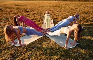 Yukarı doğru kayıyor. Bir grup kadın sahada birlikte spor yapıyorlar..