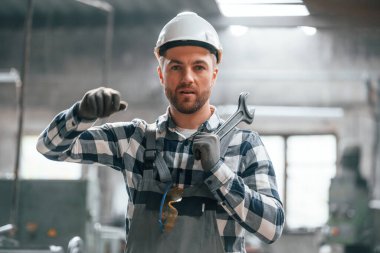 Beyaz kasketli. Üniformalı fabrika çalışanı içeride..