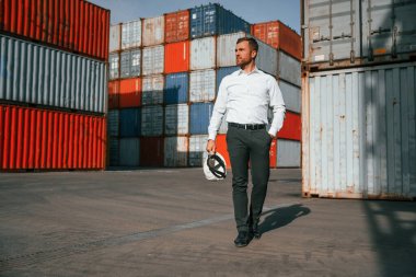 Ön manzara. Erkek işçi konteynırlarla birlikte olay yerinde..