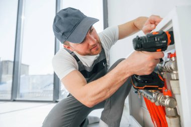 Boru döşeniyor. Tamirci modern odada kapalı alanda çalışıyor..