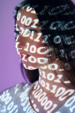 İkili makine kodu. Stüdyoda projektör neon ışıkları altında güzel genç bir kadın var..