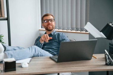 Kağıt uçak fırlatmak. Adam modern büroda çalışıyor. İş ve serbest meslek anlayışı.