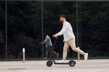 Mobilete binmek. Tarz sahibi adam gündüz vakti dışarıda..