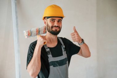 Boya rulosuyla. Adam dairede tamirat yapıyor..